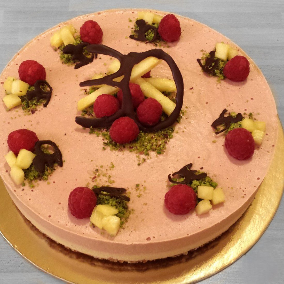 Cheesecake al cioccolato decorata con frutti freschi e ananas